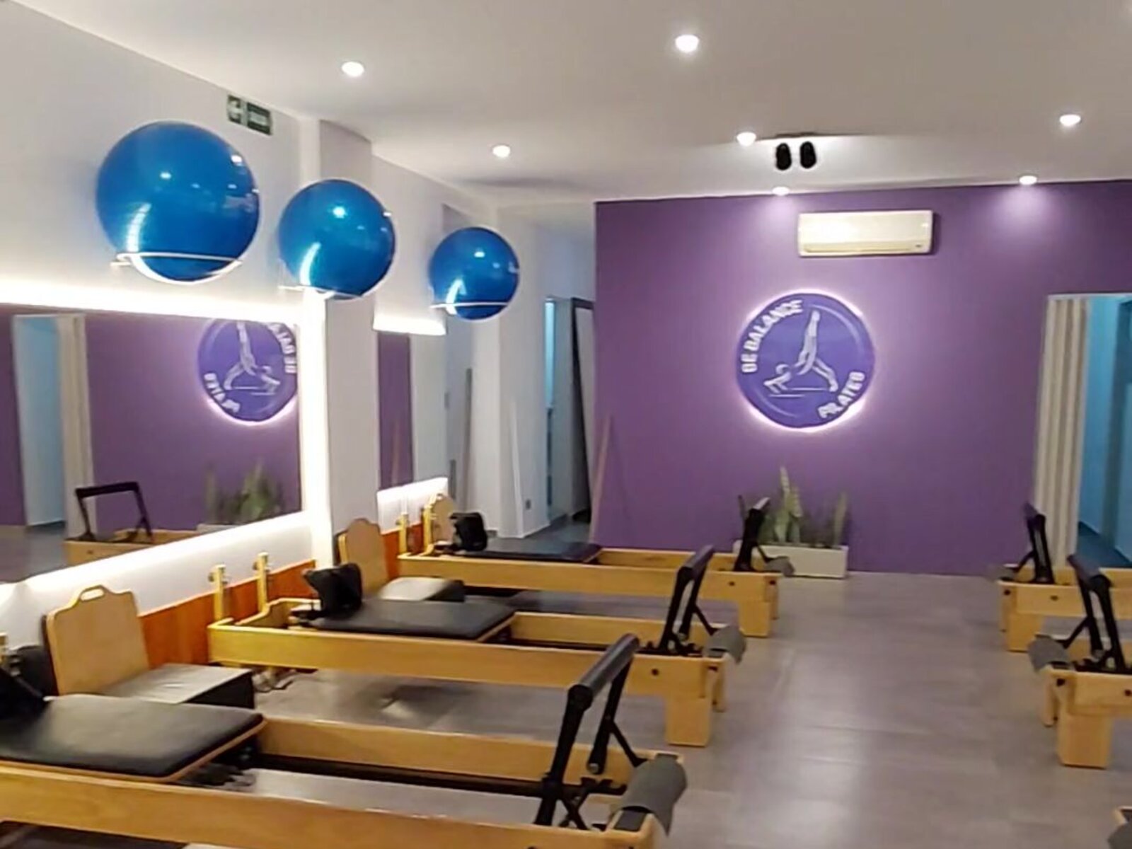Interior del estudio Be Balance en Villa Ballester con pared violeta, reformers y pelotas suizas